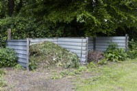 Large compost bins at Lewis Cottage, NGS Devon garden. Spring.