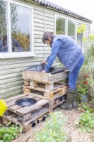 Woman placing liner in the top of the pallet bug hotel