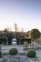 Topiary including box, lollipop Portuguese laurels and yew hedging in a formal garden in winter