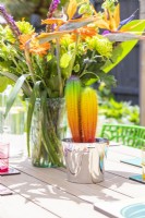 Decorative rainbow cactus next to bouquet on dining table