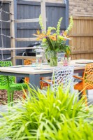 Outdoor dining area beyond a bed of crocosmias