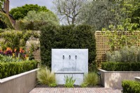 Suburban garden in spring - contemporary water fountain in suburban garden
