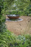 Circular corten steel water feature in the RHS Planet-Friendly Garden at RHS Hampton Court Palace Garden Festival 2022