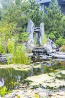 Natural large stone waterfall feature at opposite end of large round pond