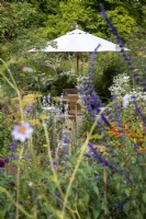 Parasol and garden furniture in a cottage garden