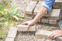 Woman placing pavers in a wedge shape