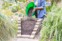 Woman filling the wedge with compost