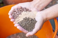Woman holding gravel, sand and compost in hands