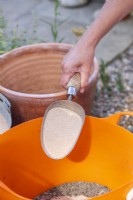 Woman putting sand in the trug