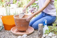 Woman filling the pot part way with the sand mixture