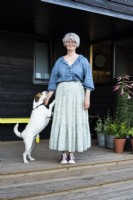 Woman standing in front of shed with pet terrier
