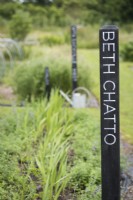 Wooden markers with the names of inspirational women gardeners at a flower farm in July