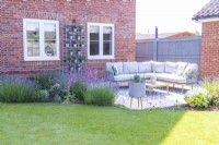 Large corner settee separated from lawn by mixed border