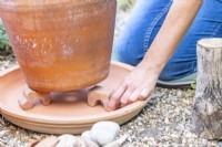 Woman placing feet under the pot in the dish