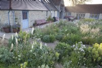 View of Hailstone Barn Gloucestershire, across late May perennial planting.