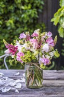Mixed bouquet of pink and cream - Lathyrus odorata, Dianthus, Lupins, Alchemilla mollis and roses in wooden tray on table