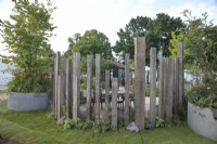 Reclaimed semicircular timber screen in The Vitamin G Garden at RHS Hampton Court Palace Garden Festival 2022