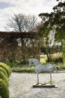 Decorative tin horse in a country garden in spring