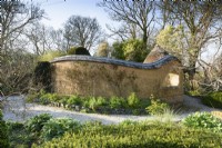 Cob-built enclosure in a country garden in March