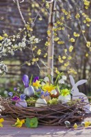 Easter arrangement with grapevine wreath nest, coloured egg shells planted with spring flowers.