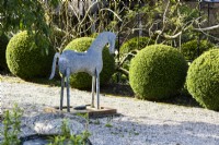 Decorative tin horse in a country garden in spring