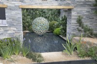 Water feature surrounded by stone walls in A Peaceful Escape at RHS Malvern Spring Festival 2022