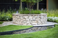 Raised bed with integral bench built with irregular cladding stone.  
