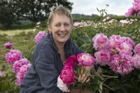 Claire Austin with Paeonia blooms in her nursery field