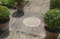 Tiled feature taken from an idea at Sissinghurst set in gravel path with pots of clipped Buxus balls