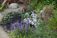 Small pond bordered by Liriope muscari, Ophiopogon and pebbles