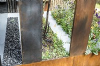 Beds with charcoal, charred wood regenerating Eucalyptus dalrympleana seedling and fire damaged wood.
The Body Shop Garden 
Designer: Jennifer Hirsch

RHS Chelsea Flower Show 2022 Sanctuary Gardens