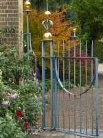 Entrance Court at East Ruston Old Vicarage Gardens, Norfolk, decorative iron work gateway, walls and containers at the beginning of Autumn