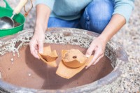 Woman placing crocks in large container