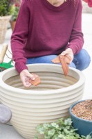 Woman placing crocks in in large container