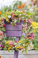 Wreath and trug full of materials used on a wooden chair