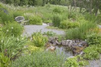 Traditional northern-Norwegian garden with wooden garden-seat; small pond; meadow area. Midummer.  Perennials. 

Allium, Bergenia, Primula, Persicaria, Aconitum, Filipendula ulmaria 'Flore Pleno', Hosta sieboldiana.