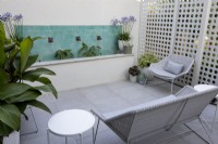 Contemporary patio with white sunscreen, water fountain and white garden seating