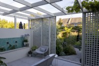Contemporary patio with fountain and white sliding sun screen with view towards garden