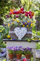 Outdoor arrangement with spring flowers including tulips, pansies and wildflowers.