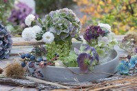 Small autumn bouquets with hydrangea blossoms and chrysanthemums, fruits of sloe and ivy, grasses, bark, and sweet chestnut