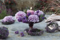 Table decoration with a candle, decorative chrysanthemums, budding heather ball and wreath, berries from the Callicarpa bodinieri and hebe