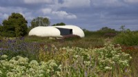 The Radic Pavilion designed by architect Smiljan Radic in the Oudolf Field at Hauser and Wirth Somerset in late summer