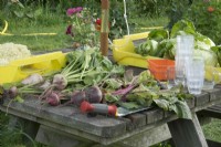 Beetroot on a wooden surface and cabbages in crate