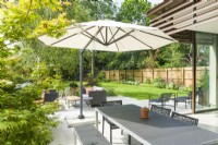 View of an outdoor living space next to a contemporary house extension. July