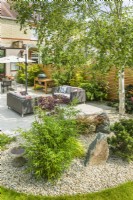 View of a Japanese inspired garden surrounding an outdoor living space. Bamboo, Japanese Maples, dwarf pine tree, rocks, stone chippings and birch tree. July
