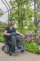 Patient in wheelchair under the rusted steel archway.

Plants include: trained apple trees in blossom with tulips 'Angelique' and 'Recreado'.

Horatio's Garden South West - Salisbury
The Duke of Cornwall Spinal Treatment Centre