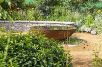 Rusted circular reflecting pool underplanted with Erigeron karvinskianus