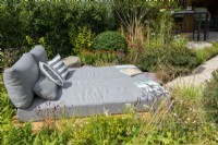 Evora Daybed surrounded by planting - The Outdoor Living Garden, RHS Hampton Court Palace Garden Festival 2022