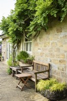 Bench and table surrounded by troughs of plants at Cow Close Cottage in North Yorkshire in July