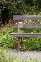 Thermos flask on a wooden bench - Guide Dogs 90th Anniversary Garden, RHS Chelsea Flower Show 2021